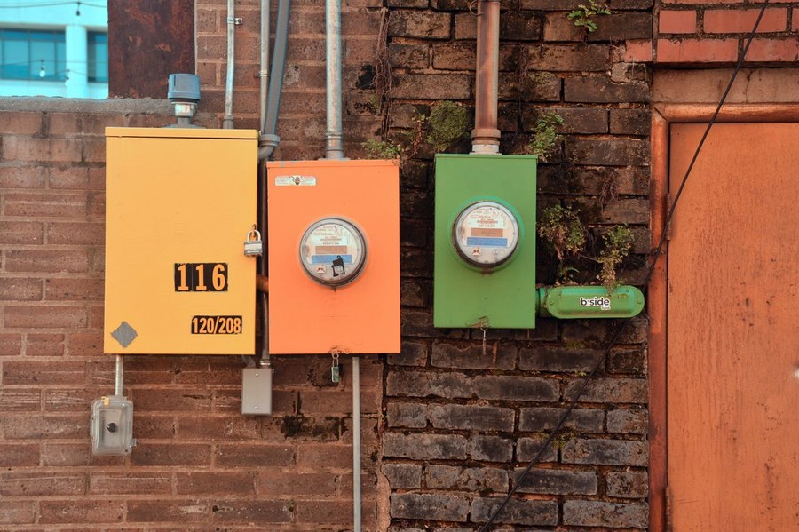 Wall of separate utility meters mounted on a brick exterior wall